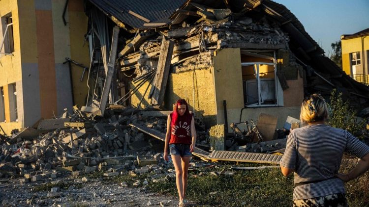 Mulheres em frente a um prédio escolar destruído após um ataque com mísseis em Druzhkivka, região de Donetsk, em 30 de agosto de 2022, em meio à invasão russa da Ucrânia. (Photo by ANATOLII STEPANOV / AFP)