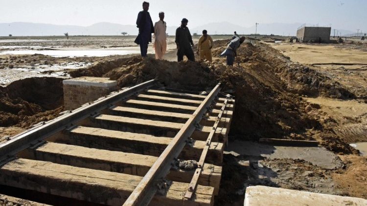 Trabalhadores reparam linha de trem atingida pela enxurrada em Quetta, em 31 de agosto de 2022. AFP/Barnaras Khan
