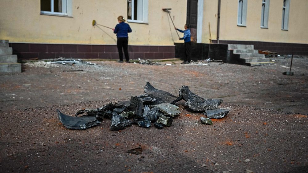 Trabalhadores limpam a fachada de um prdio escolar danificado aps um ataque com msseis em Kharkiv em 3 de setembro de 2022, em meio  invas?o russa da Ucr?nia. (Foto de SERGEY BOBOK/AFP)