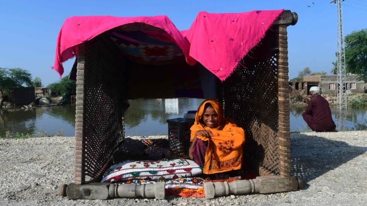 A flood-affected resident poses for a photograph at her makeshift tent in the flood-hit area of Shikarpur in Sindh province