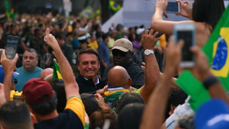 Brazilian President Jair Bolsonaro greets supporters during a campaign stop in Rio de Janeiro