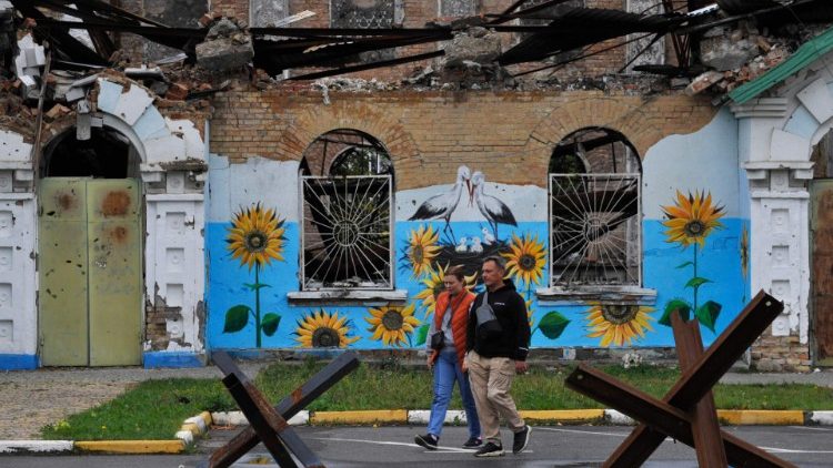 A couple walks past a destroyed building in Izyum in eastern Ukraine, after the city was freed by Ukrainian forces