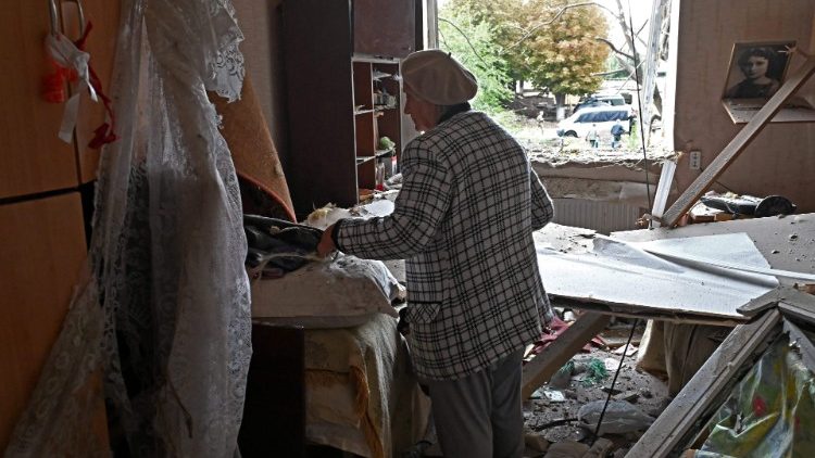 Iryna Kuzkova, 83, limpa destroços em seu apartamento em um prédio parcialmente destruído por um ataque de mísseis em Kharkiv em 12 de setembro de 2022 em meio à invasão russa da Ucrânia. (Foto de SERGEY BOBOK/AFP)