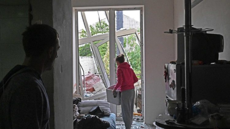 Uma moradora local recolhe seus pertences em um prédio parcialmente destruído por um ataque com mísseis em Kharkiv em 12 de setembro de 2022, em meio à invasão russa da Ucrânia. (Foto de SERGEY BOBOK/AFP)
