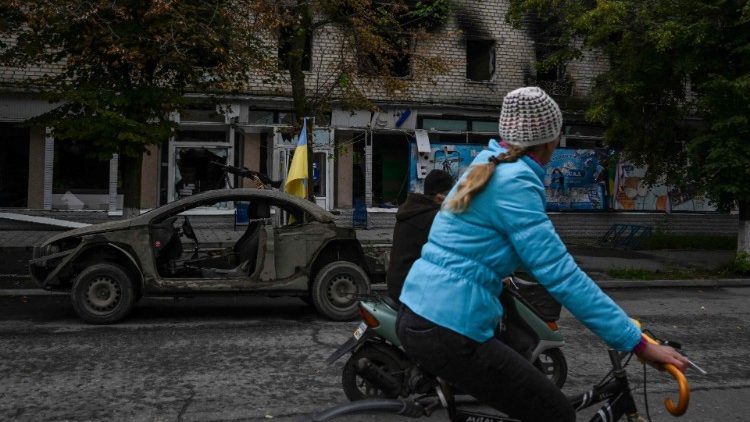 Um morador local anda de bicicleta em uma rua em Izyum, leste da Ucrânia, em 14 de setembro de 2022. - O presidente ucraniano em 14 de setembro de 2022 prometeu "vitória" em uma visita à cidade estratégica de Izyum, que foi recentemente recapturada da Rússia pelo exército de Kyiv em uma contra-ofensiva relâmpago. (Foto de Juan BARRETO/AFP)