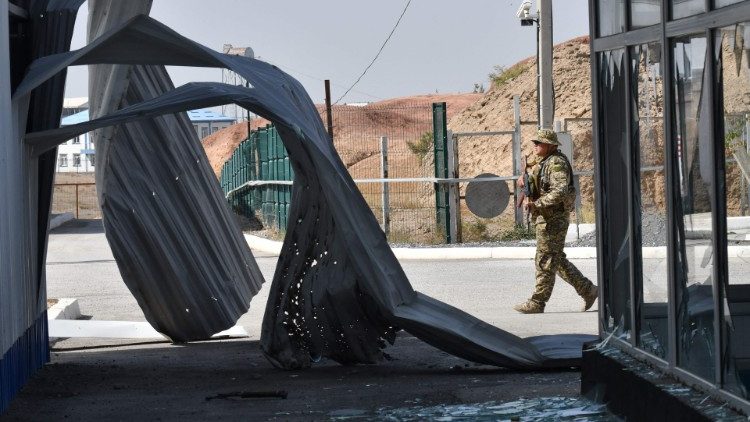 A Kyrgyz soldier patrols a burnt-out border checkpoint near the frontier with Tajikistan