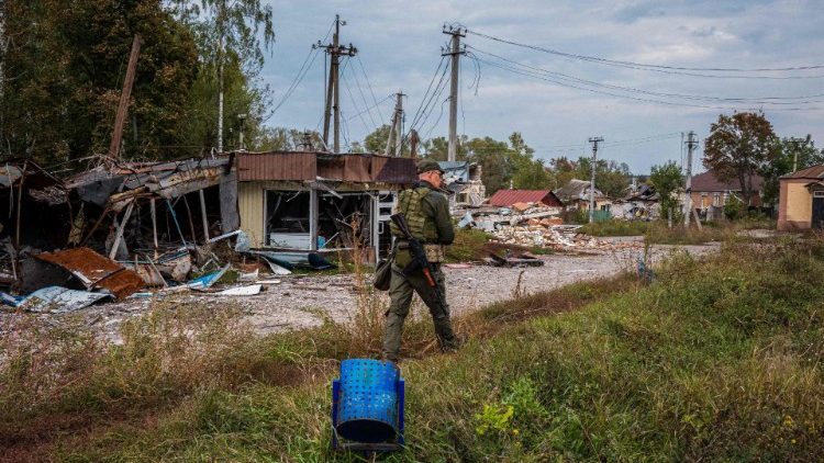 Żołnierz ukraińskiej Gwardii Narodowej dokonujący inspekcji budynków zniszczonych podczas rosyjskiej okupacji w obwodzie charkowskim
