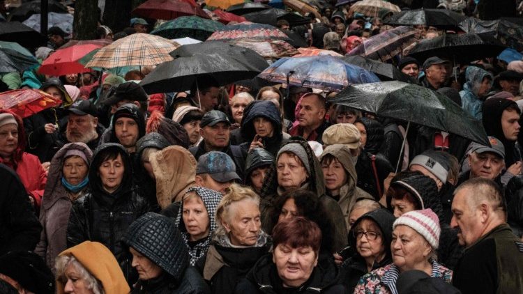 Pessoas esperam por alimentos durante sua distribuição para cerca de 3.000 pessoas pela filial local da Caritas Internationalis, uma organização de caridade católica, em Kharkiv, em 27 de setembro de 2022. (Foto de Yasuyoshi CHIBA / AFP)