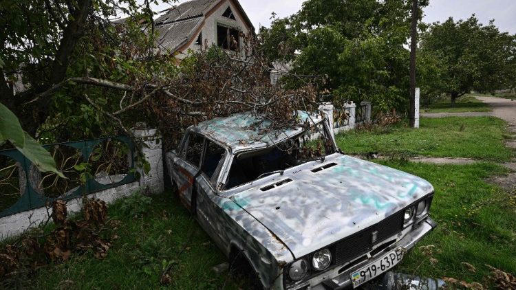 Uma fotografia tirada em 27 de setembro de 2022 mostra um carro civil destruído que foi reaproveitado por soldados russos, ao lado de uma casa danificada na vila recentemente libertada de Vysokopillya, região de Kherson, em meio à invasão russa da Ucrânia. (Foto de Genya SAVILOV / AFP)