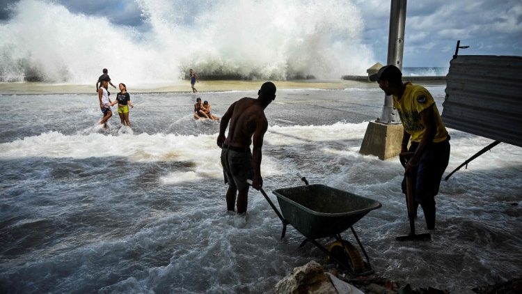 Trabajadores comunitarios recogen escombros dejados en el malecón de La Habana tras el paso del huracán Ian el pasado miércoles.