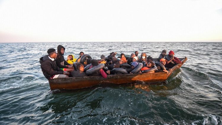 Migrants from Sub-Saharan Africa sit in a makeshift boat that was being used to arrive on the Italian Coast