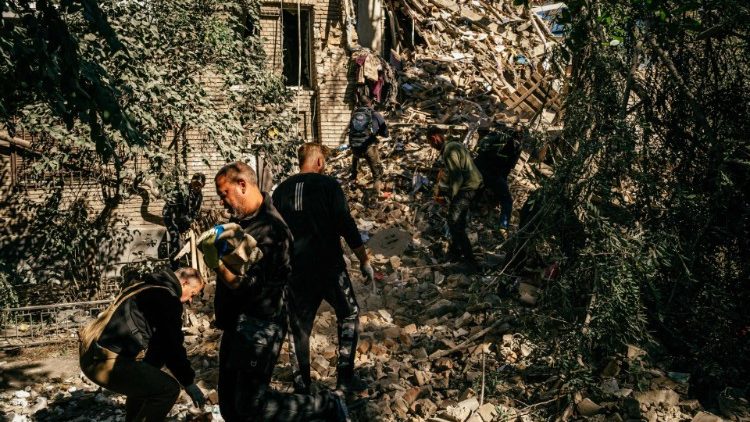 Voluntários removem os escombros de um prédio em busca de sobreviventes após um ataque em Zaporizhzhia em 6 de outubro de 2022, em meio à invasão russa da Ucrânia. (Foto de Dimitar DILKOFF/AFP)