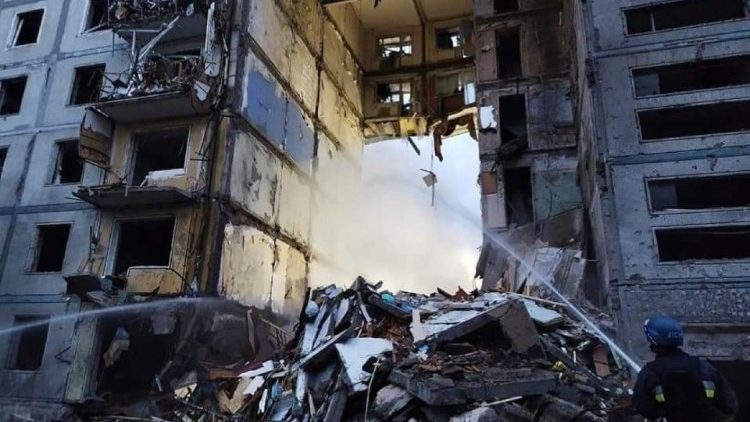 A rescuer extinguishes a fire in a residential building in Zaporizhzhia, Ukraine 