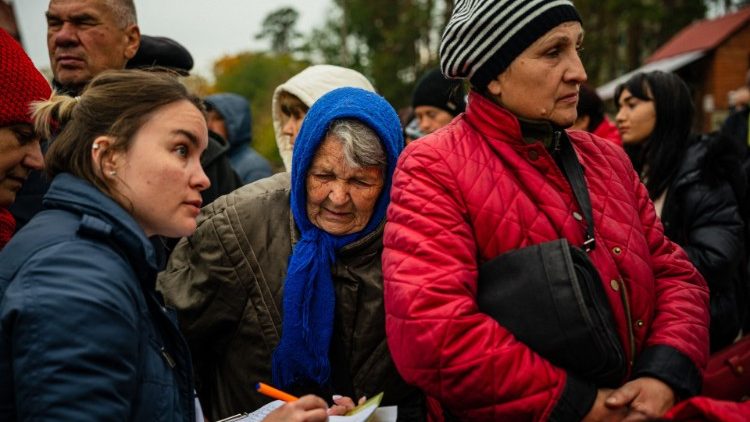 Moradores locais esperam na fila para receber comida e ajuda humanitária em Svyatohirs'k, região de Donetsk, em 20 de outubro de 2022, após a liberação da área. (Foto de Dimitar DILKOFF/AFP)