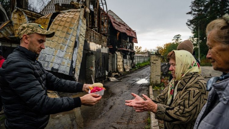 Moradores locais recebem alimentos e ajuda humanitária em Svyatohirs'k, região de Donetsk, em 20 de outubro de 2022, após a liberação da área. (Foto de Dimitar DILKOFF/AFP)