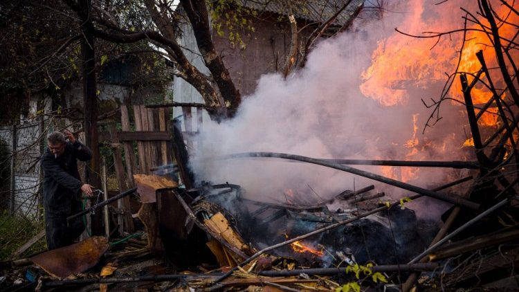 Um morador local trabalha para extinguir um incêndio após um bombardeio na cidade de Bakhmut, na região de Donbas, no leste da Ucrânia, em 23 de outubro de 2022, em meio à invasão militar da Rússia na Ucrânia. (Foto de Dimitar DILKOFF/AFP)