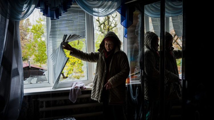 Uma idosa examina sua casa danificada após um bombardeio na cidade de Bakhmut, na região de Donetsk, em 25 de outubro de 2022, em meio à invasão russa da Ucrânia. - Após a morte de sete civis em 24 de outubro, em Bakhmut, os moradores remanescentes da pequena cidade mineira no leste da Ucrânia, devastada pelo fogo cruzado nos últimos três meses, estão se agarrando à decisão de ficar, arriscando suas vidas. (Foto de Dimitar DILKOFF/AFP)