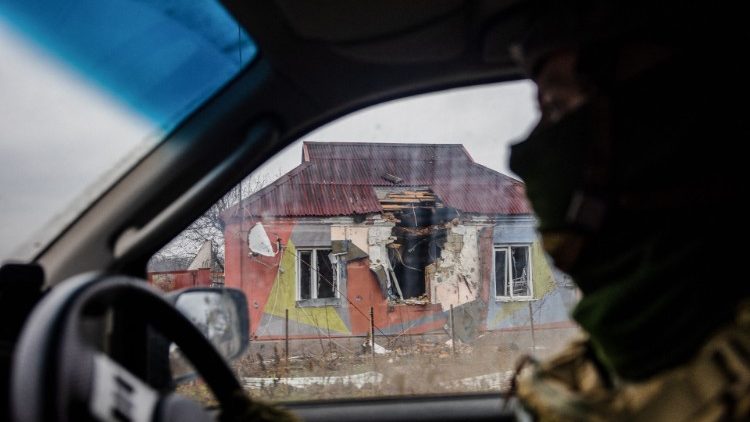 Um soldado ucraniano dirige um carro por uma casa danificada após um bombardeio na região de Donetsk, no leste da Ucrânia, em 30 de outubro de 2022, em meio à invasão da Ucrânia pela Rússia. (Foto de Dimitar DILKOFF/AFP)