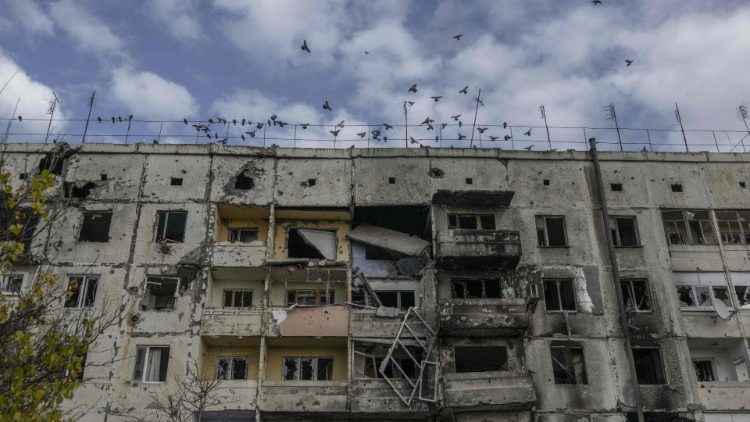 Pássaros sobrevoam um prédio danificado na vila de Arkhanhelske, na região de Kherson, em 3 de novembro de 2022, anteriormente ocupada pelas forças russas. (Foto por BULENT KILIC/AFP)