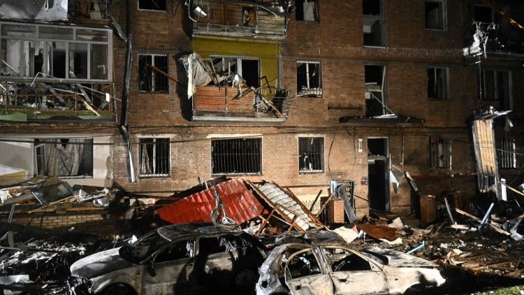 Verbrannte Autos vor einem zerstörten Wohngebäude am Rand von Kyiv 