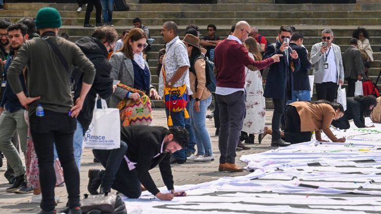 Menschen in Bogotá beschriften ein Transparent, das an den Friedensschluss vor sechs Jahren erinnert