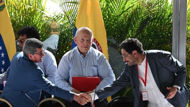 Colombia's ELN guerrilla commander shakes hand with a government delegation member during peace talks in December