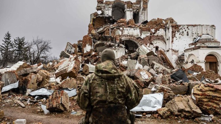 César, 50 anos, um russo que se juntou à Legião da Liberdade da Rússia para lutar ao lado da Ucrânia, fica em frente a um mosteiro destruído em Dolyna, leste da Ucrânia, em 26 de dezembro de 2022.