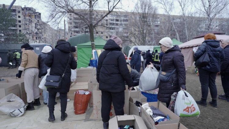 Ukrainians bring help to area residents near the bombed out building in Dnipro