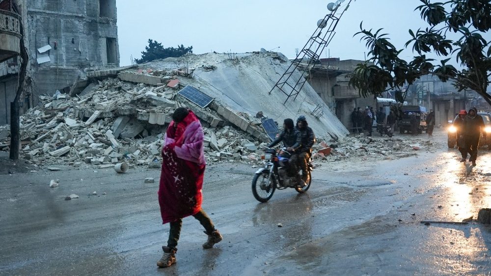 Moradores caminham ao longo de um prdio desabado aps um terremoto na cidade de Jandaris, no interior da cidade de Afrin, no noroeste da Sria, na parte controlada pelos rebeldes da provncia de Aleppo, em 6 de fevereiro de 2023. (Foto de Rami al SAYED/AFP)