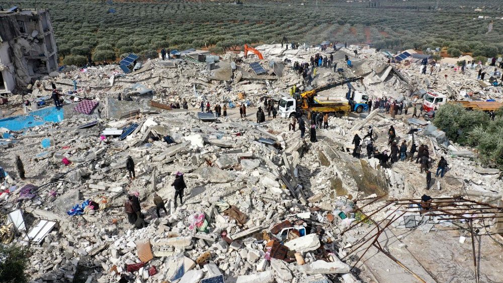 Vista area mostra residentes ajudando equipes de resgate na busca de sobreviventes sob os escombros no povoado de Besnia, Provncia de Idlib. (Phovy by Omar Haj Kadour/AFP)