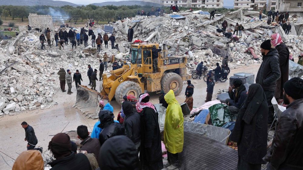 Moradores e equipes de resgate procuram پ e sobreviventes em meio aos escombros de prdios desabados aps um terremoto na vila de Besnaya, na provncia de Idlib, no noroeste da , controlada por rebeldes, na fronteira com a Turquia, em 6 de fevereiro de 2022.  (Foto de OMAR HAJ KADOUR/AFP)