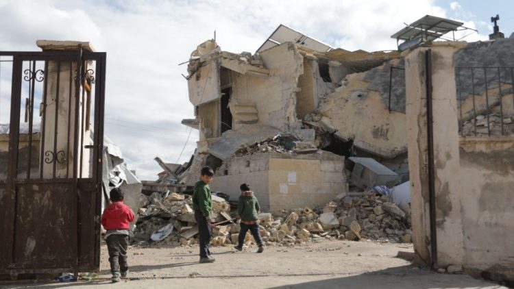 Crianças sírias se reúnem ao lado de uma escola que desabou na cidade de Azaz, na fronteira com a Turquia, em 7 de fevereiro de 2023, após um terremoto mortal. (Foto de Bakr ALKASEM/AFP)