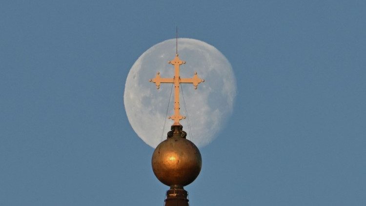 A lua, com a cpula da Baslica de S?o Pedro e a cruz em primeiro plano, em 8 de fevereiro de 2023. (Foto de Alberto PIZZOLI/AFP)