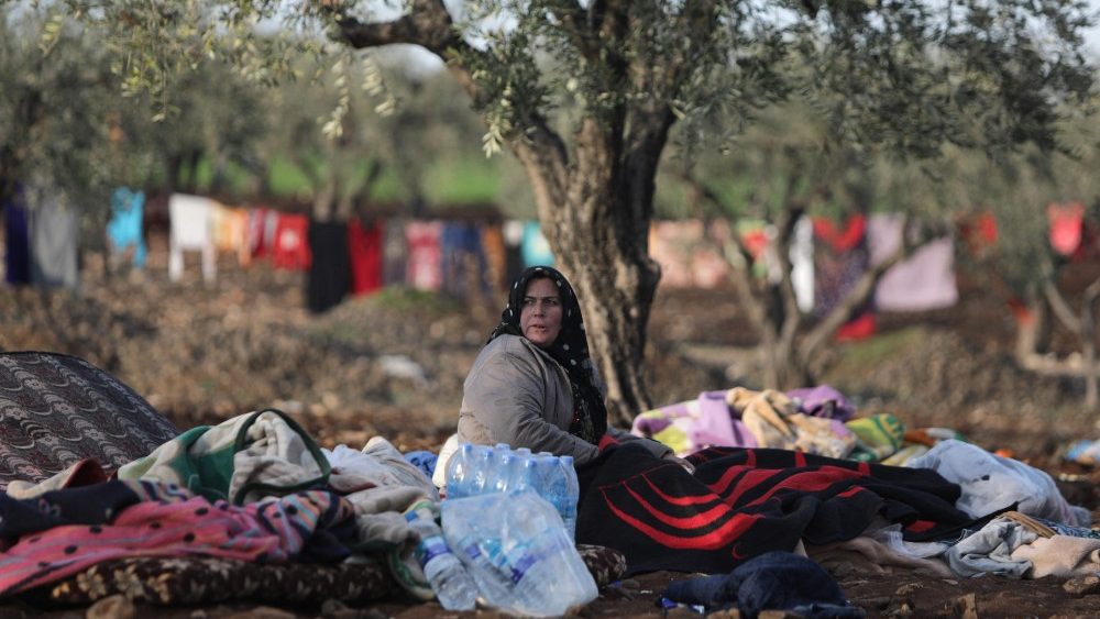 Uma mulher sria, deslocada como resultado do terremoto mortal que atingiu a Turquia e a  h dois dias, descansa sob uma rvore em um campo nos arredores da cidade de Jindayris, controlada pelos rebeldes, em 8 de fevereiro de 2023. (Foto de Bakr ALKASEM/AFP)