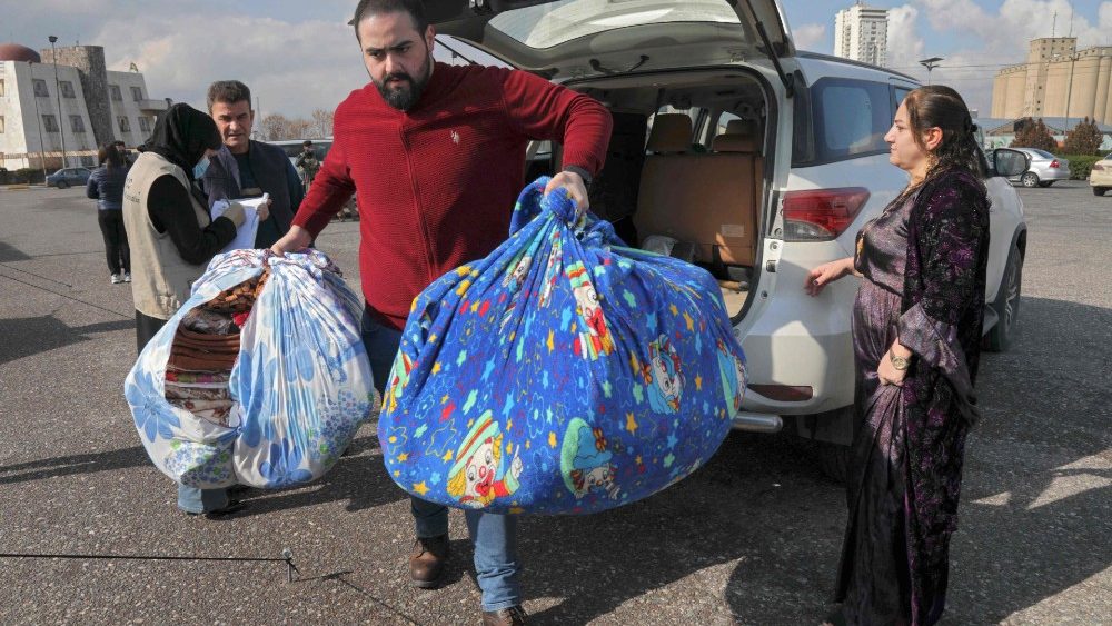 Voluntrios iraquianos coletam cobertores doados em Arbil, capital da regi?o curda aut?noma do norte do Iraque, em 9 de fevereiro de 2023, para serem enviados  Turquia e   aps um terremoto mortal que atingiu os dois pases h dois dias. (Foto de SAFIN HAMED/AFP)