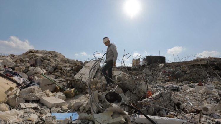 A Syrian boy walks amid the rubble of his family home in Jindayris