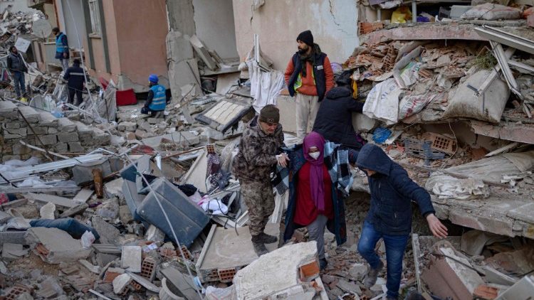 Una mujer busca a sus familiares entre los escombros de edificios derrumbados es escoltada, en Hatay, el 14 de febrero de 2023, tras el terremoto de magnitud 7,8 que sacudi el sureste del pas.