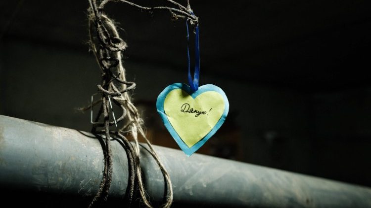 Uma decoração em forma de coração com a palavra "obrigado" em ucraniano é pendurada em um cano de fogão no abrigo do Serviço de Guarda de Fronteiras do Estado em Bakhmut em 16 de fevereiro de 2023. (Foto de YASUYOSHI CHIBA/AFP)
