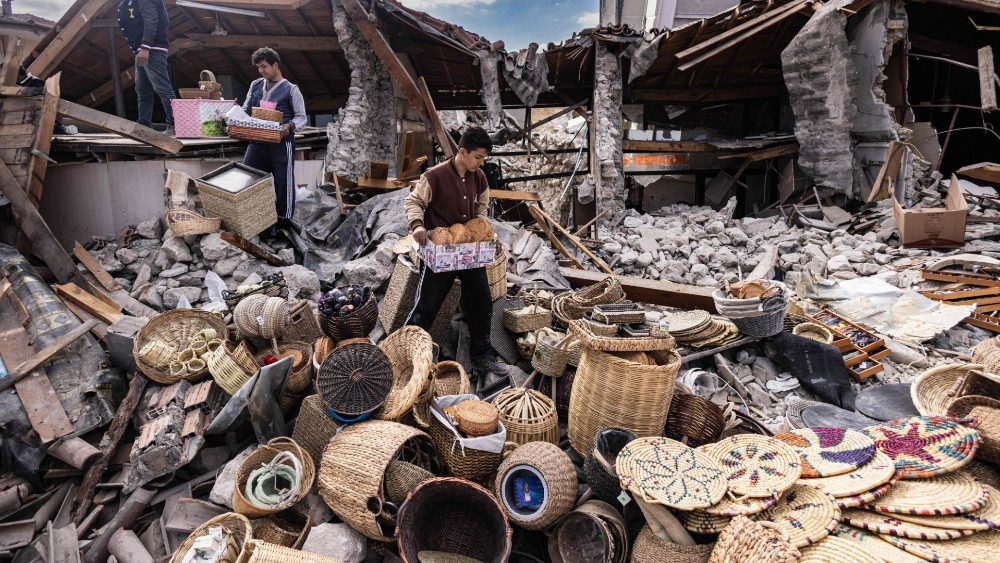 Mustafa Ozdimir ajuda sua famlia enquanto eles coletam mercadorias de sua loja destruda na cidade de Antakya em 19 de fevereiro de 2023. (Foto de Sameer Al-DOUMY / AFP)