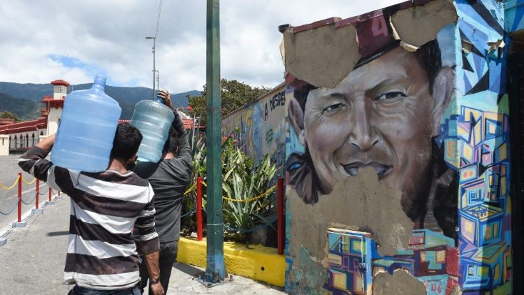 Carrying water home in a poor Caracas neighbourhood