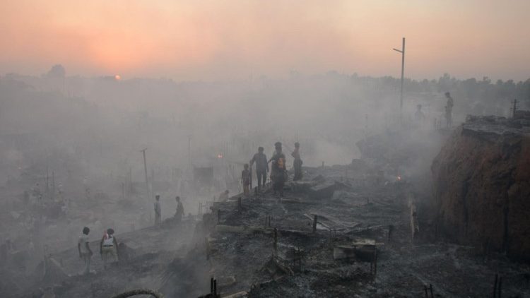 Refugiados rohingya buscan sus pertenencias entre las ruinas