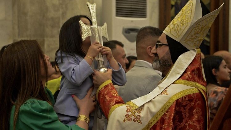 Menina iraquiana beija a cruz na Viglia Pascal na Igreja da Imaculada Concei??o em Qaraqosh (Photo by Zais Al-Obeidi)