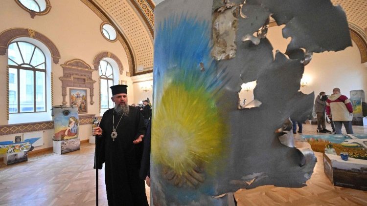 Metropolitan Epiphanius, head of the Ukrainian Orthodox Church, looks at a creation made out of Russian missiles fragments during the opening of the exhibition of art pieces made with Russian missiles fragments collected in the Kyiv region and covered with drawings by well known Ukrainian artists and children, in Kyiv, on April 27, 2023. (Photo by Sergei SUPINSKY / AFP)