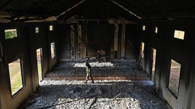 An Indian soldier inspects the ruins of a ransacked church in Manipur State