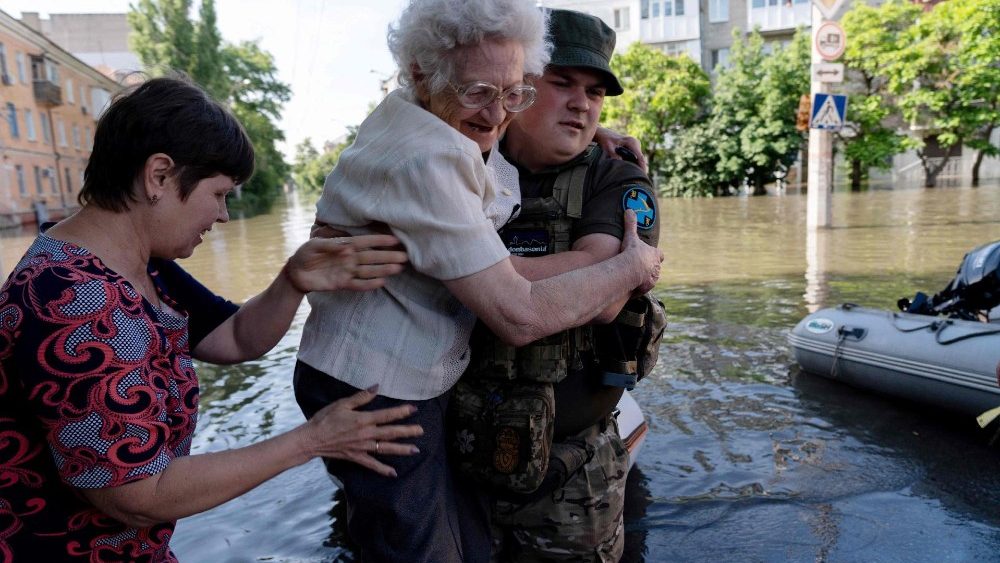  Um soldado ucraniano ajuda os residentes locais durante uma evacua??o de uma rea inundada em Kherson em 7 de junho de 2023, aps danos sofridos na barragem da usina hidreltrica de Kakhovka. A Ucr?nia estava evacuando milhares de pessoas em 7 de junho depois que um ataque a uma grande represa controlada pela Rssia desencadeou uma torrente de gua, inundando duas dzias de aldeias e provocando temores de um desastre humanitrio. (Foto de ALEKSEY FILIPPOV / AFP)