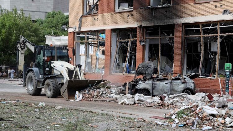 Um trator limpa os escombros no fundo de um prédio comercial, que foi danificado em um ataque russo durante a noite em Odesa em 14 de junho de 2023, em meio à invasão russa da Ucrânia. Pelo menos três pessoas morreram e 13 ficaram feridas em um ataque com mísseis russos na cidade portuária de Odesa, no sul da Ucrânia, no início de 14 de junho de 2023, disseram as autoridades. (Foto de Oleksandr GIMANOV / AFP)