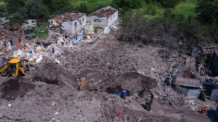 Esta vista aérea mostra trabalhadores municipais enquanto usam uma escavadeira mecânica para remover detritos de uma área residencial após um ataque russo a Kramatorsk em 14 de junho de 2023, após ataques noturnos na cidade do leste da Ucrânia. (Photo by Ihor Tkachov / AFP)
