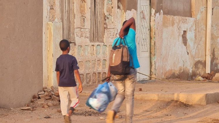 Sudanese carry their belongings as they flee ongoing battles in the capital Khartoum 