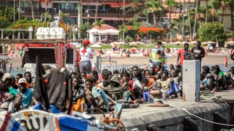 FILE PHOTO: Migrants rest on the pier after disembarking from a 'cayuco' (wooden boat) following a rescue operation on 4 July on the Spanish Canary island of Tenerife.