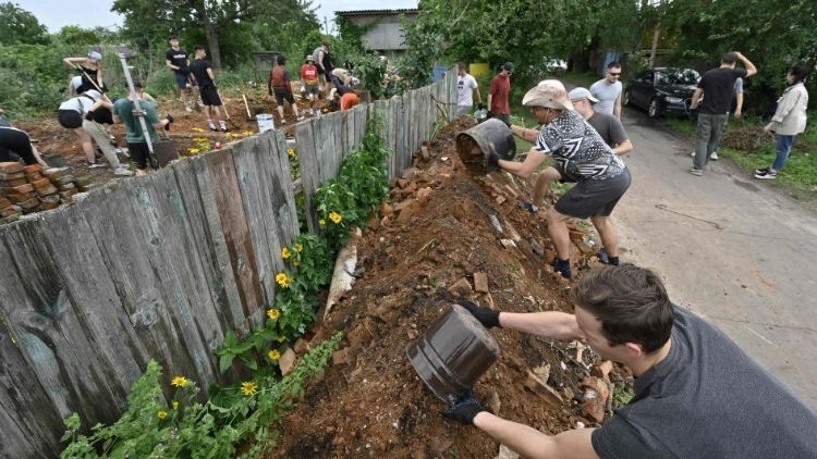 Volunteers clear the rubble at a destroyed residential house in Ukraine